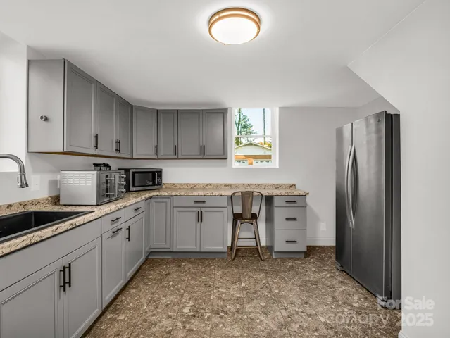 a kitchen with cabinets appliances and a window
