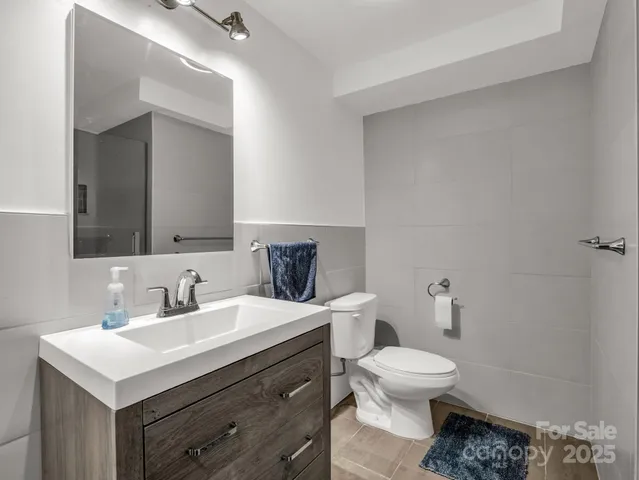 a bathroom with a sink a toilet and a mirror