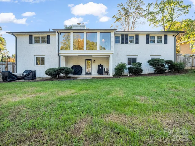 a front view of a house with a yard and trees