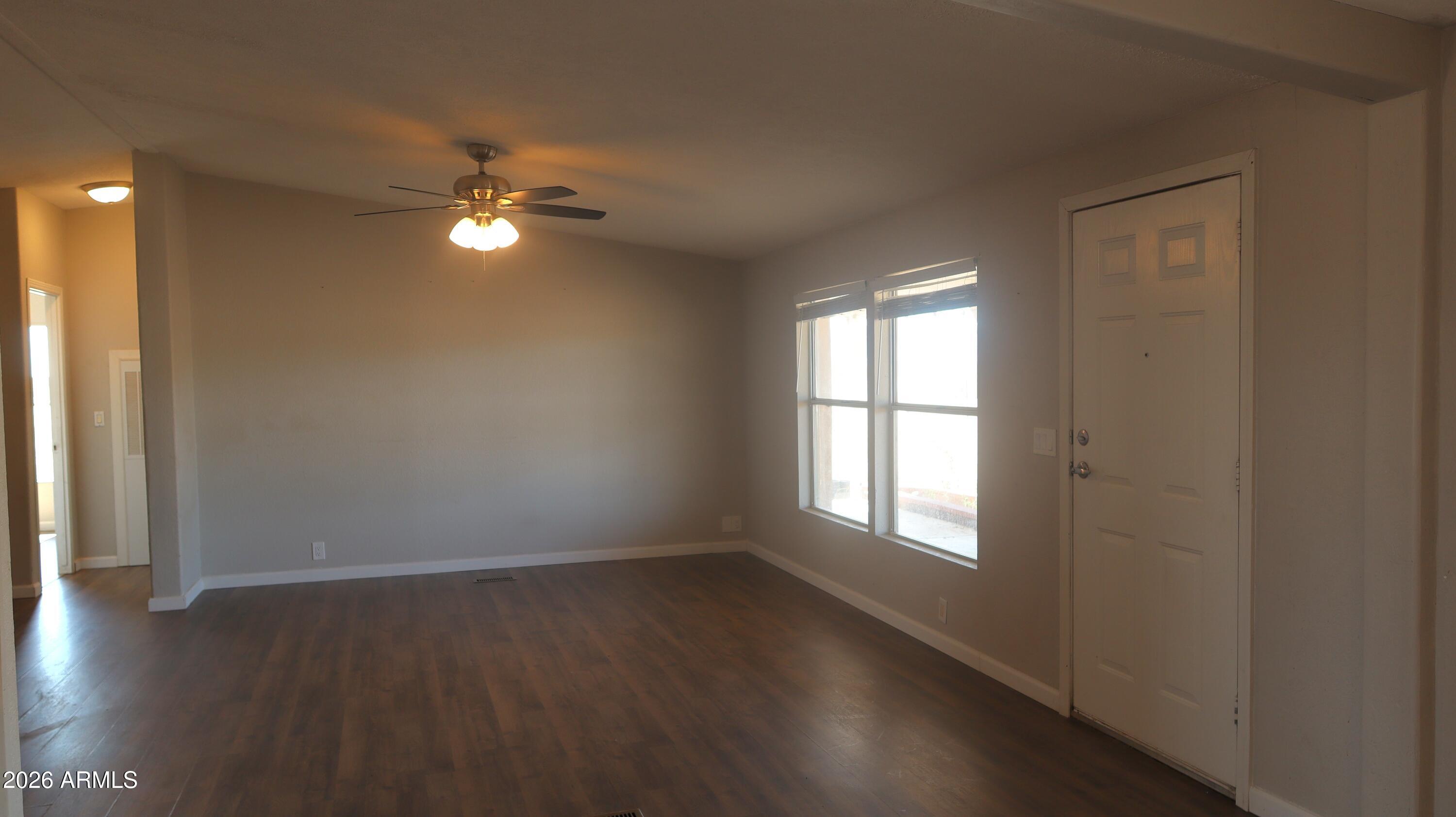 20163 North Sage Street Maricopa, AZ 85139 - Photo 11 of 54 a view of empty room with wooden floor and fan