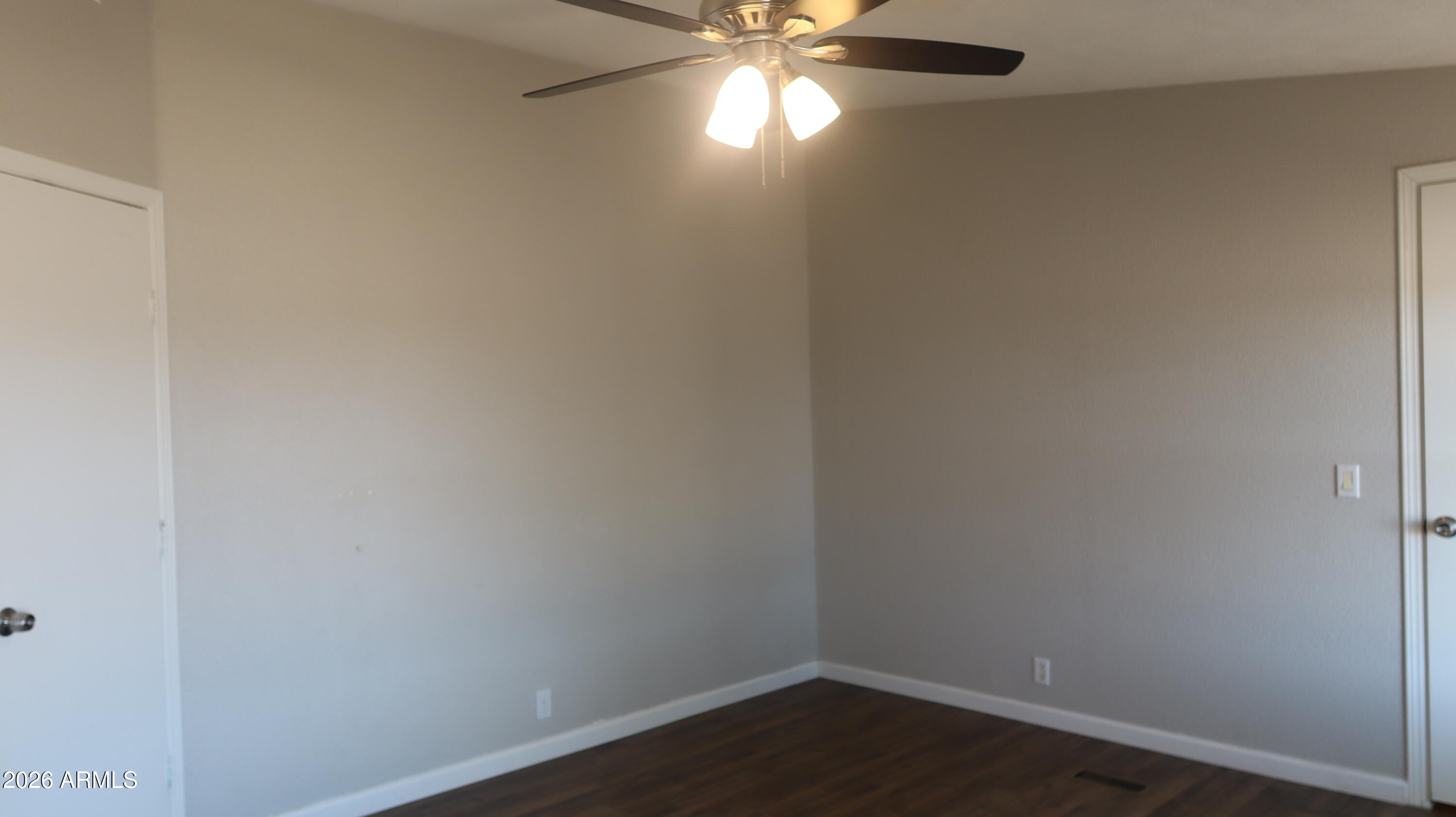 20163 North Sage Street Maricopa, AZ 85139 - Photo 16 of 54 a view of an empty room with wooden floor and a ceiling fan