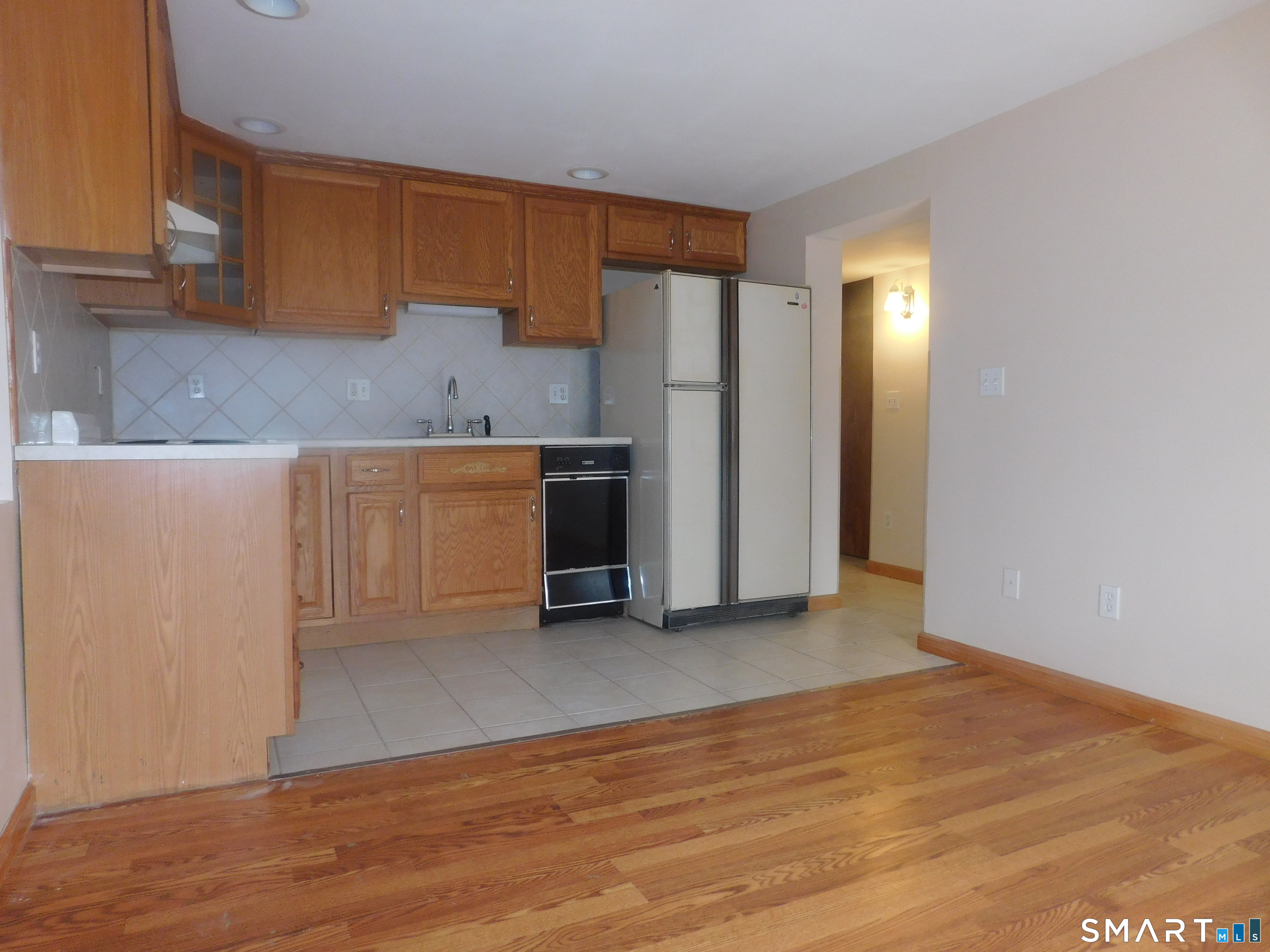 6 Daybreak Lane, Unit STUDIO Shelton, CT 06484 - Photo 4 of 7 a view of a kitchen with refrigerator and wooden cabinets