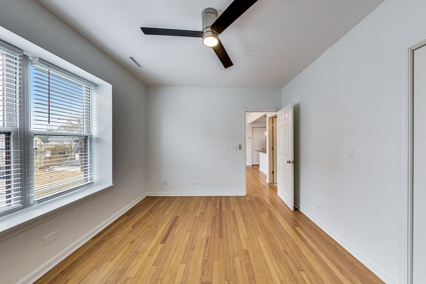 4017 North Troy Street, Unit 2W Chicago, IL 60618 - Photo 13 of 18 a view of empty room with wooden floor and fan