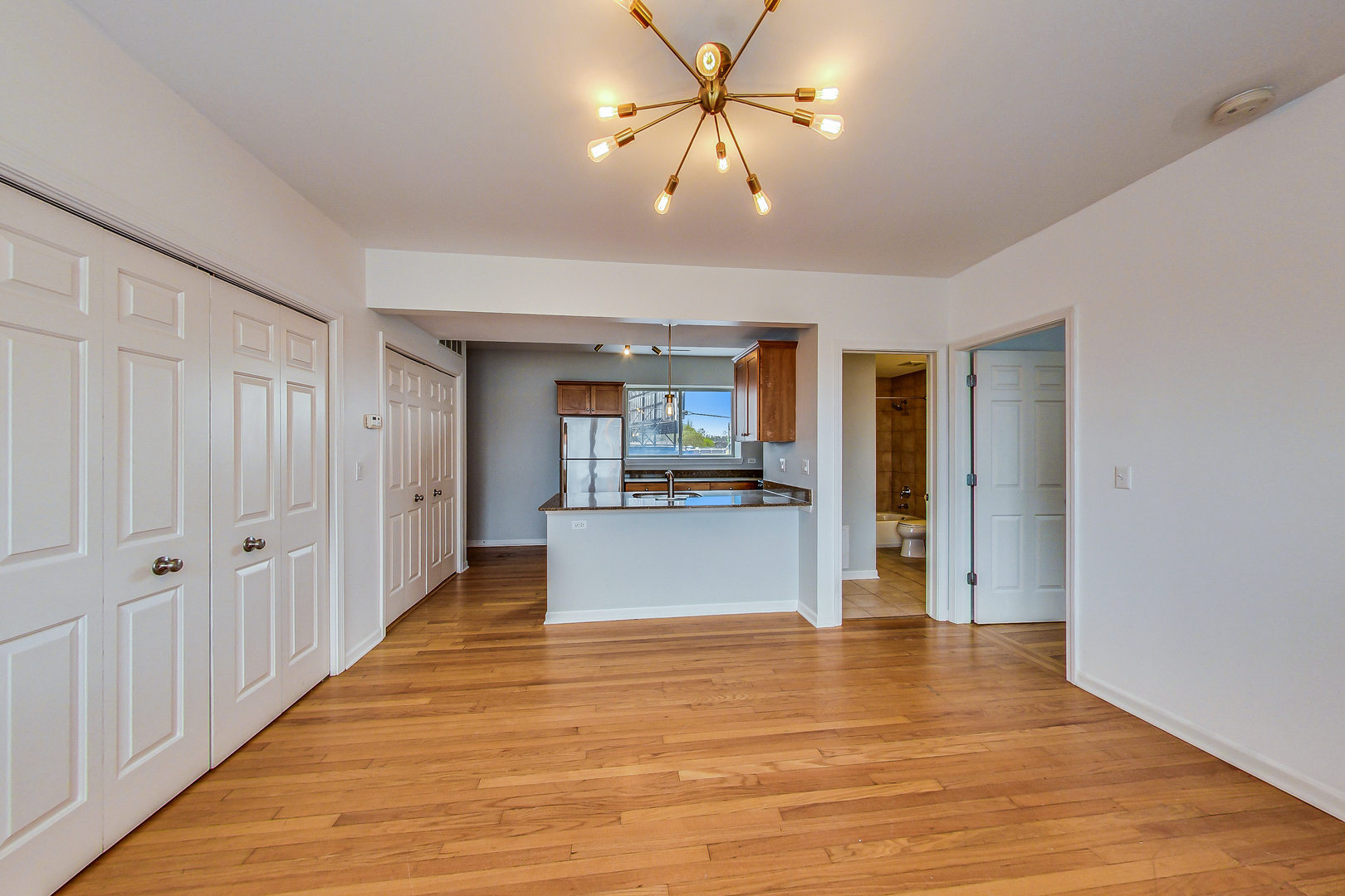 4017 North Troy Street, Unit 2W Chicago, IL 60618 - Photo 5 of 18 a view of a hallway with wooden floor and a kitchen