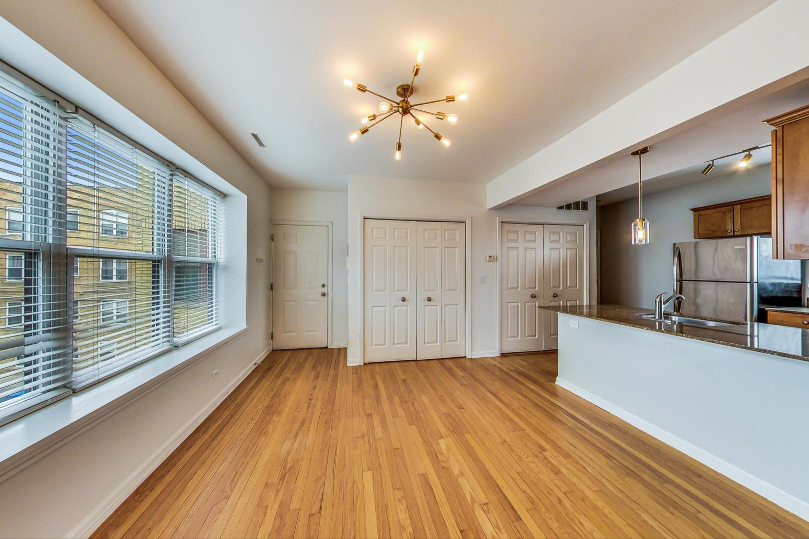 4017 North Troy Street, Unit 2W Chicago, IL 60618 - Photo 6 of 18 a view of an empty room with wooden floor and a window