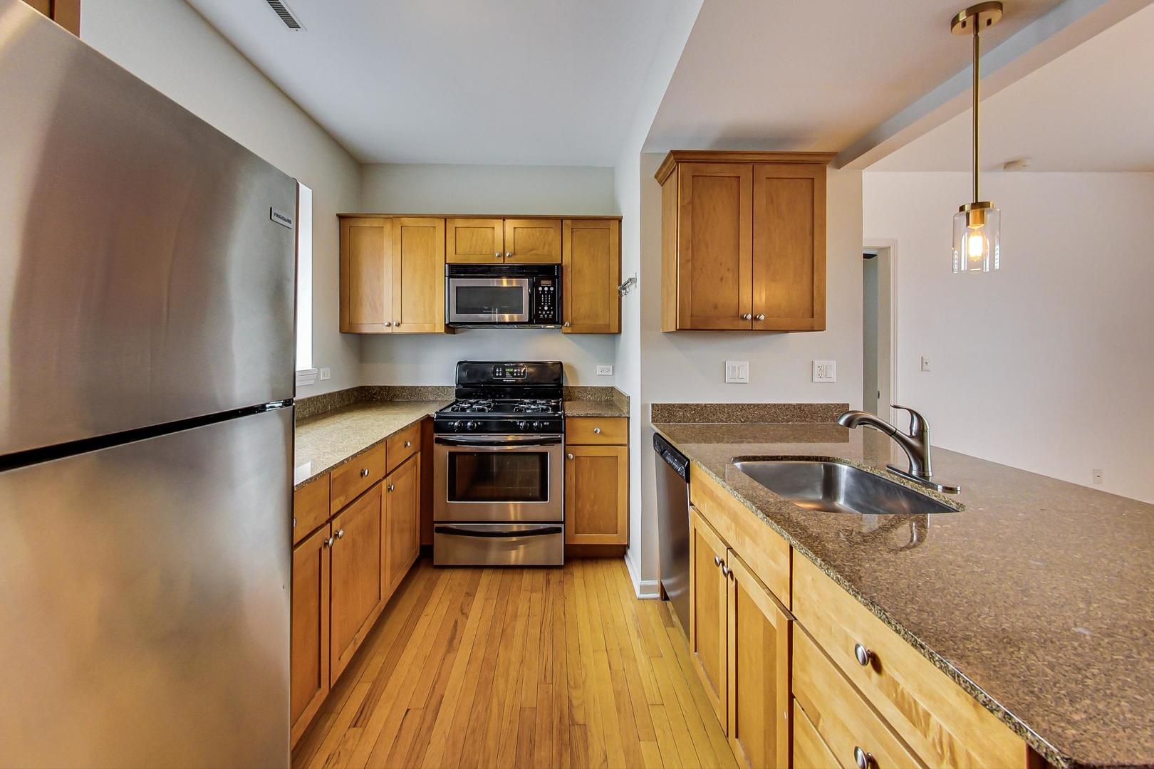 4017 North Troy Street, Unit 2W Chicago, IL 60618 - Photo 8 of 18 a kitchen with granite countertop a sink stove and refrigerator