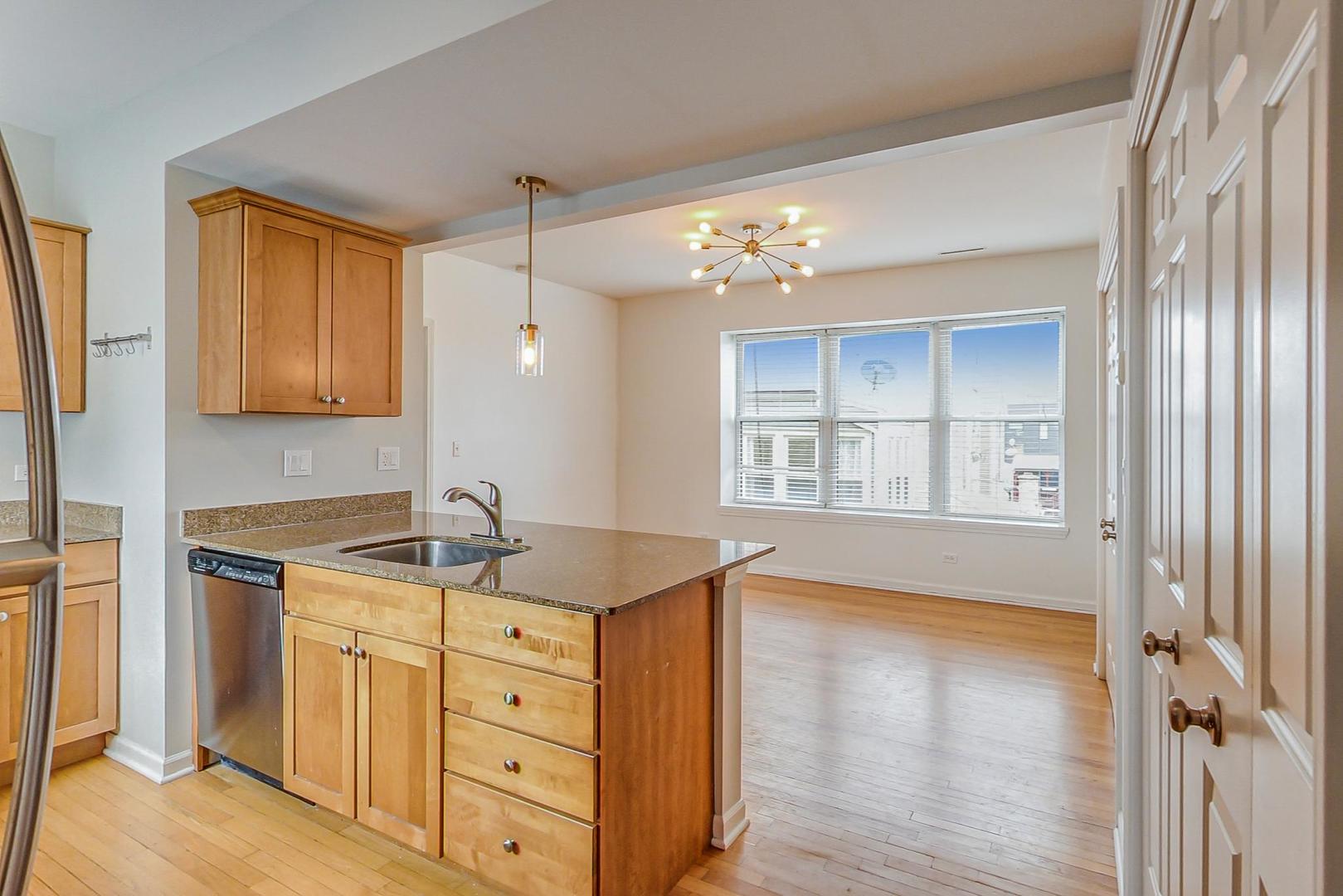4017 North Troy Street, Unit 2W Chicago, IL 60618 - Photo 10 of 18 a view of cabinets a wooden floor and windows in a room