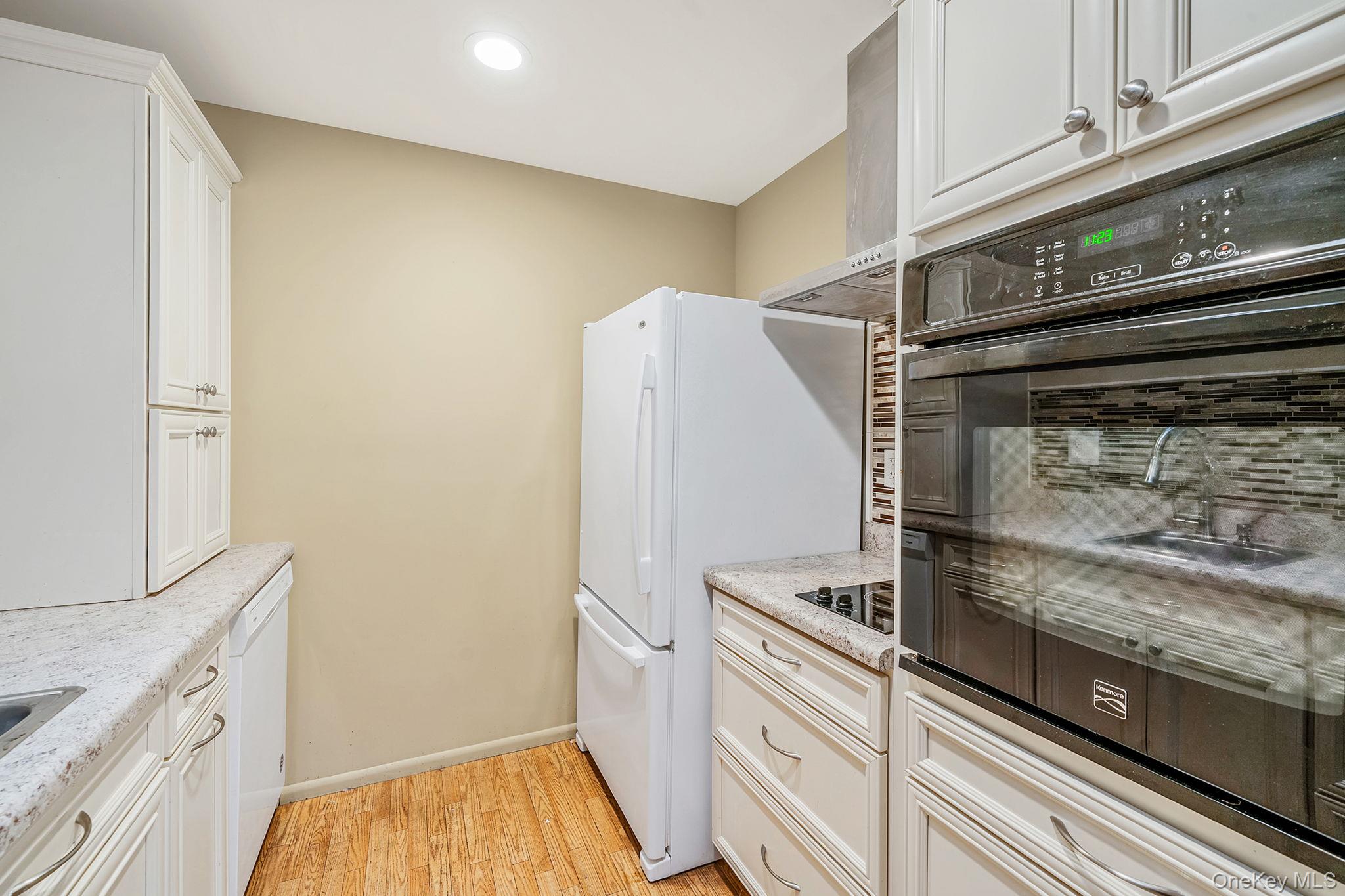 116 B Exmore Court Ridge, NY 11961 - Photo 11 of 19 a kitchen with a stove and a refrigerator