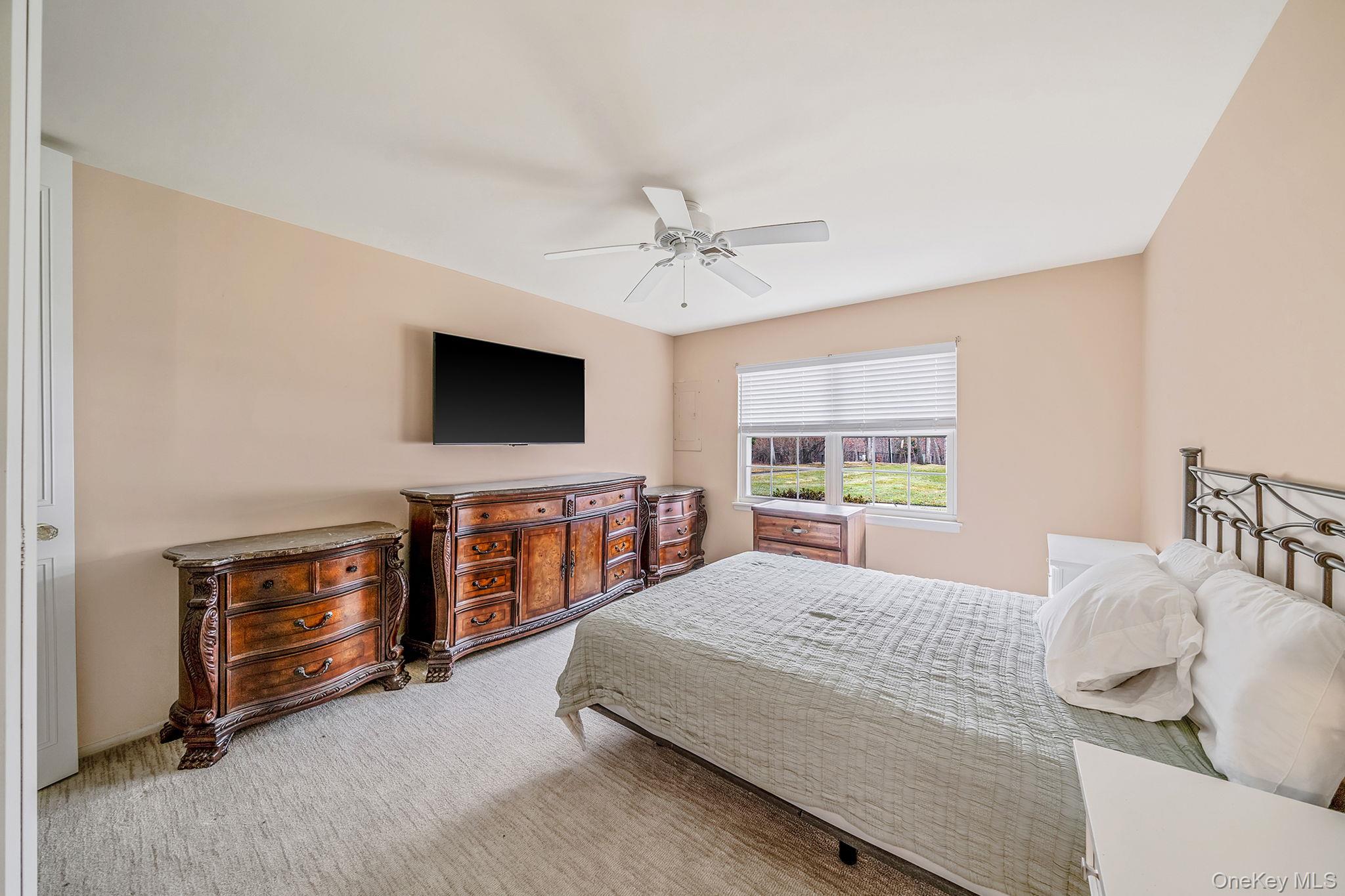 116 B Exmore Court Ridge, NY 11961 - Photo 16 of 19 a bedroom with a bed and a flat screen tv