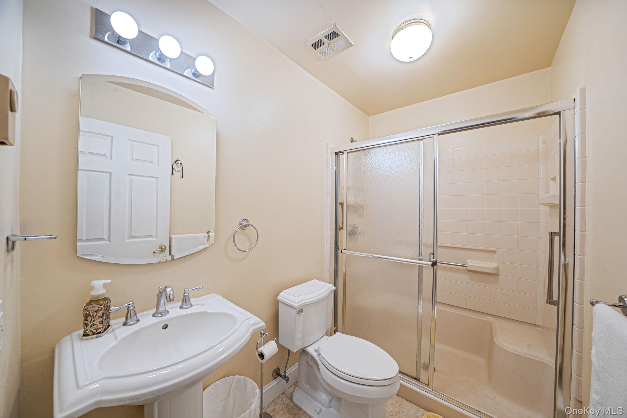 116 B Exmore Court Ridge, NY 11961 - Photo 18 of 19 a bathroom with a toilet a sink and a mirror