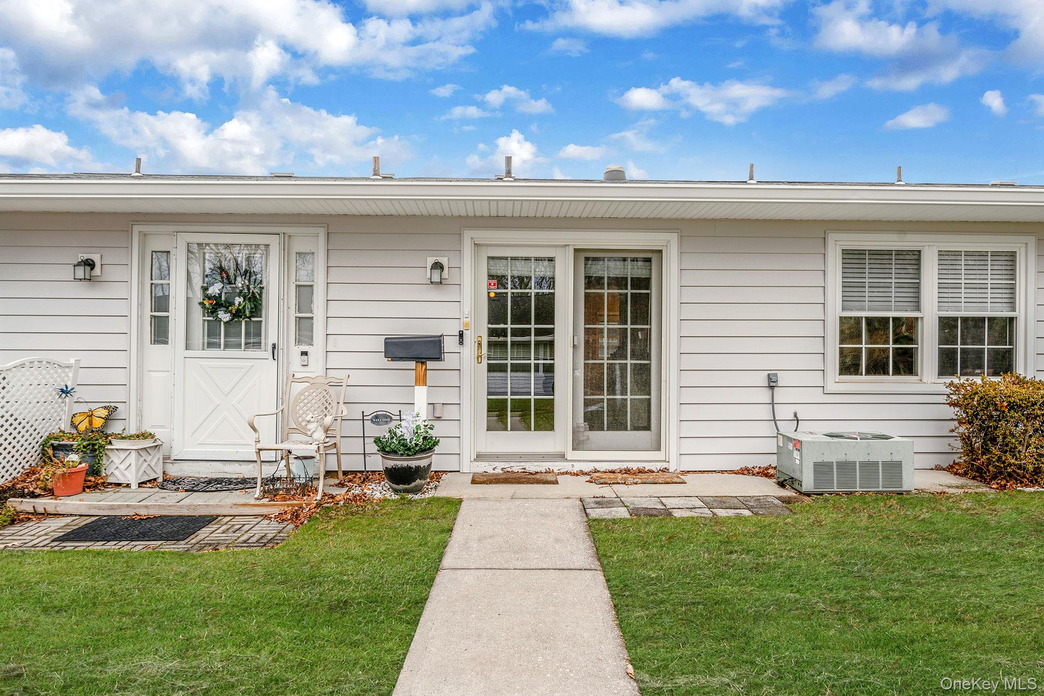 116 B Exmore Court Ridge, NY 11961 - Photo 3 of 19 a front view of a house with a yard