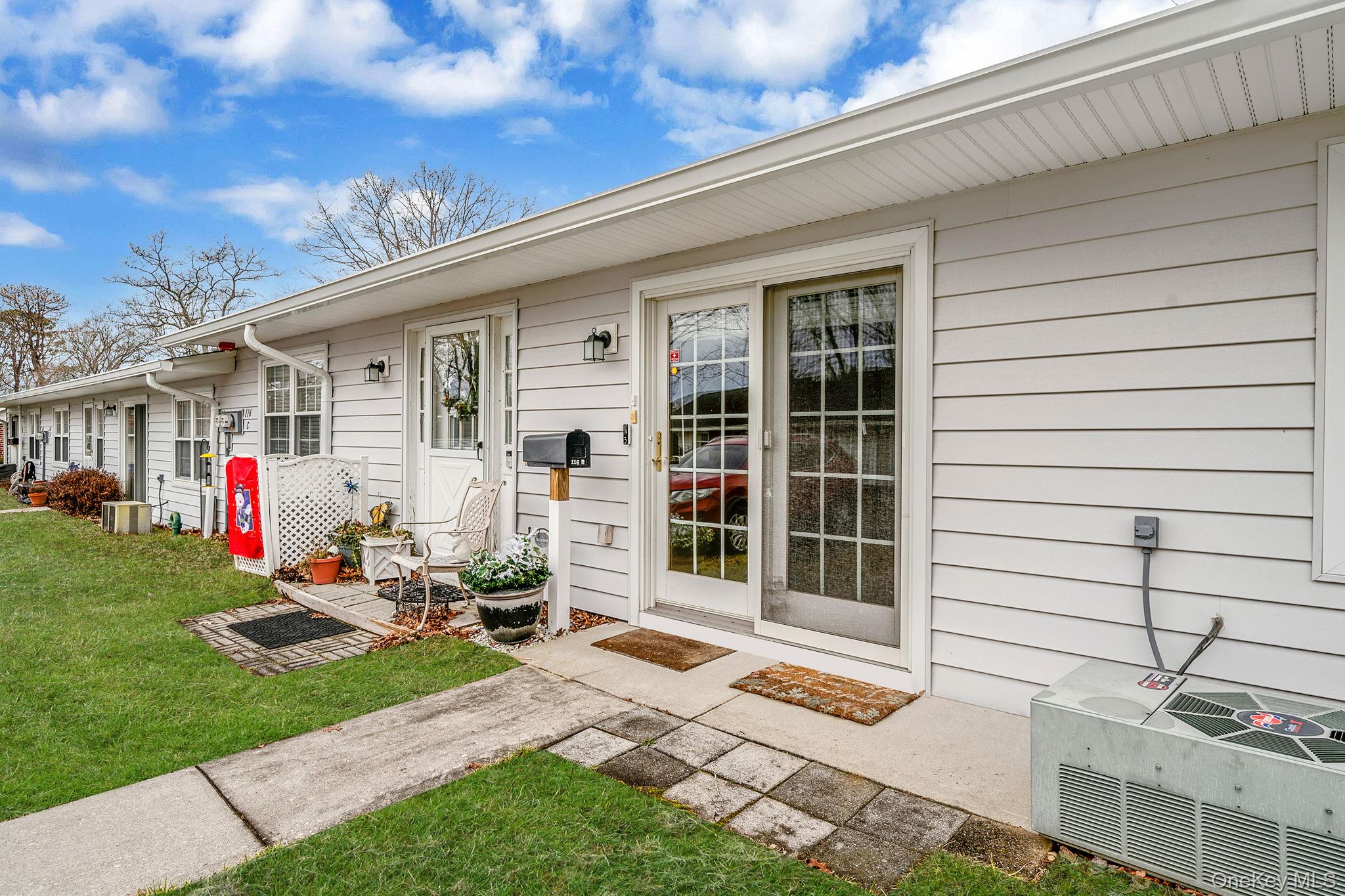 116 B Exmore Court Ridge, NY 11961 - Photo 4 of 19 a front view of a house with a patio
