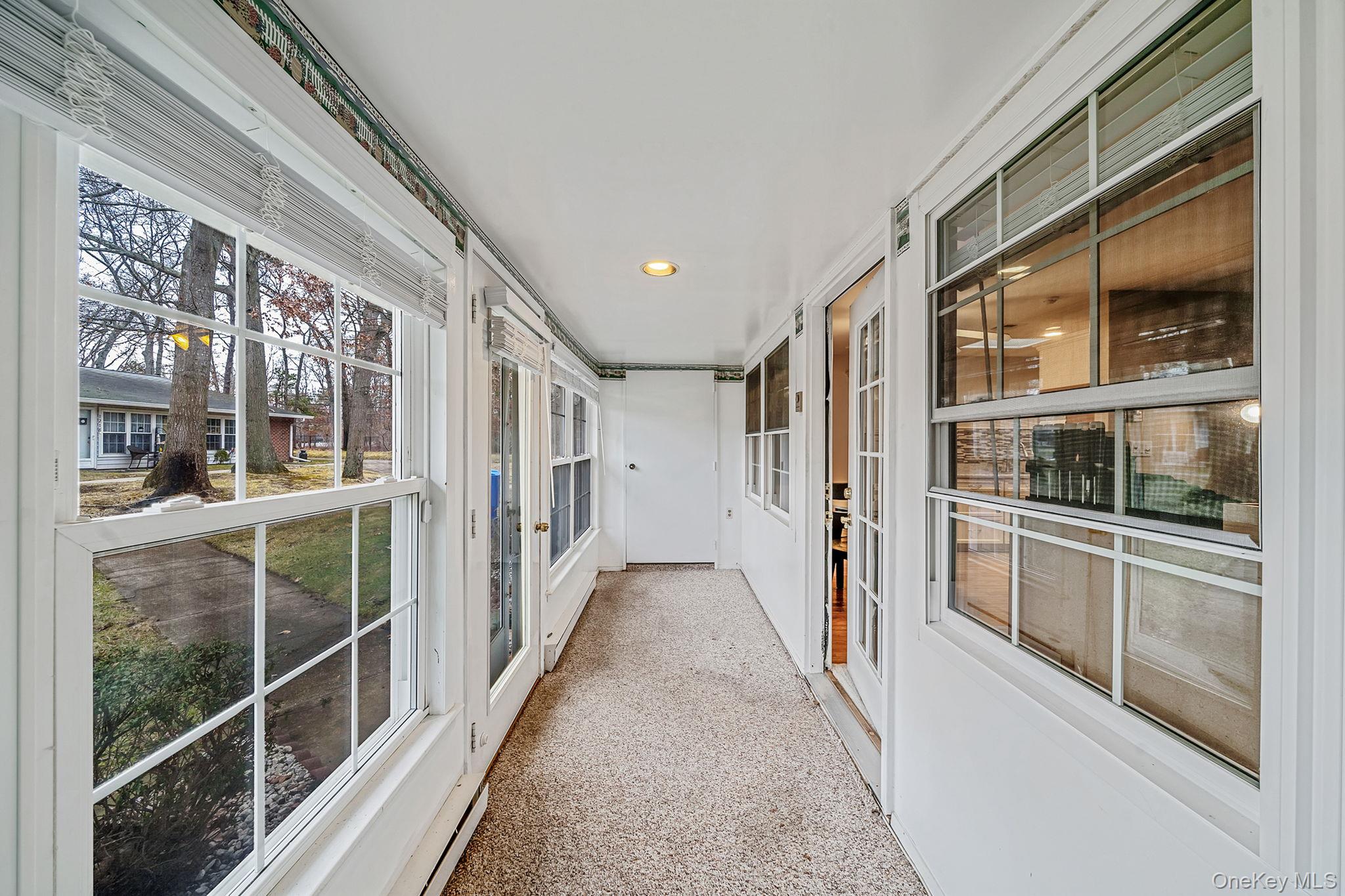 116 B Exmore Court Ridge, NY 11961 - Photo 5 of 19 a view of a hallway with wooden floor and windows