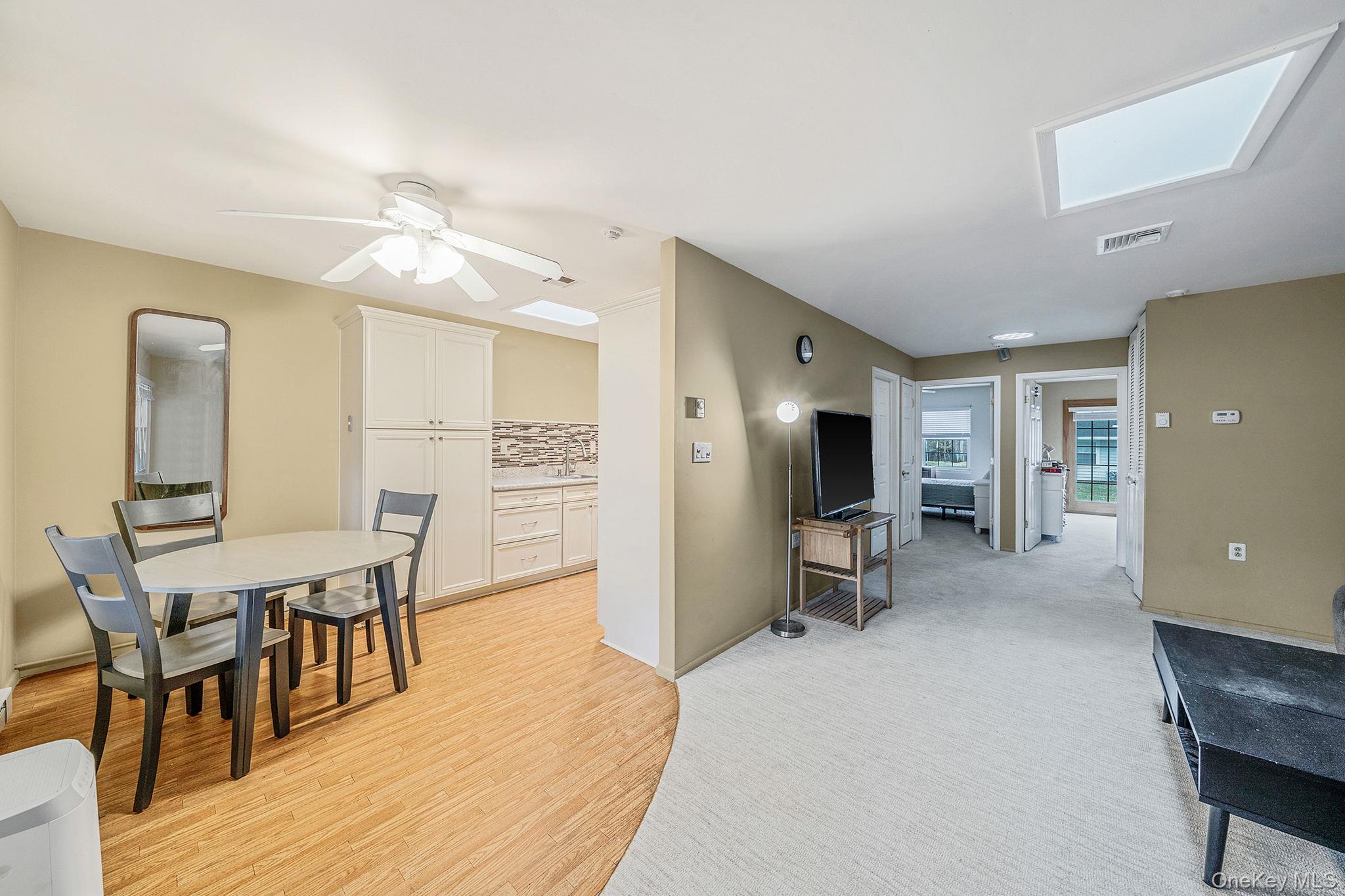 116 B Exmore Court Ridge, NY 11961 - Photo 6 of 19 a view of a dining room with furniture and a wooden floor