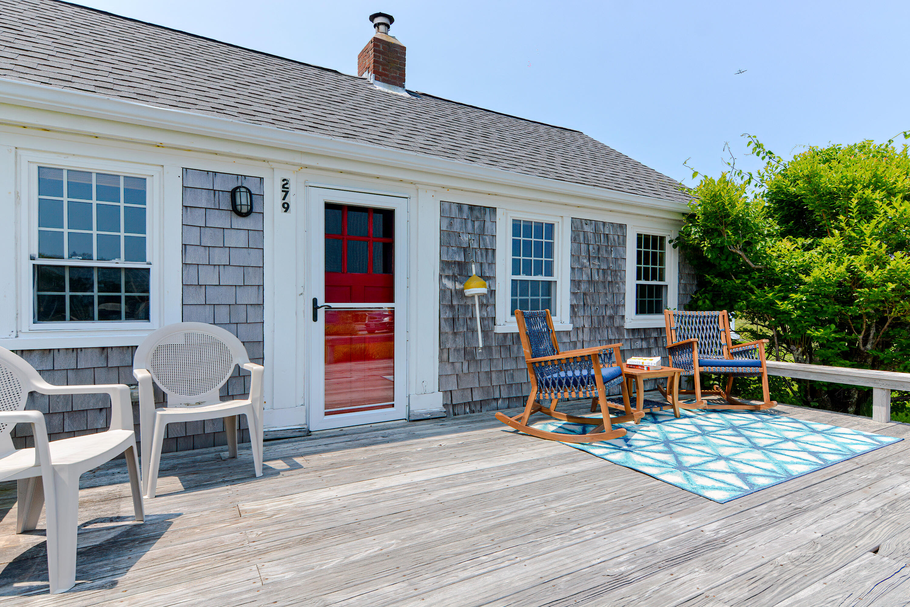 279 Harbor Point Road, Unit 12 Cummaquid, MA 02675 - Photo 2 of 35 a view of a patio with table and chairs with wooden floor and plants