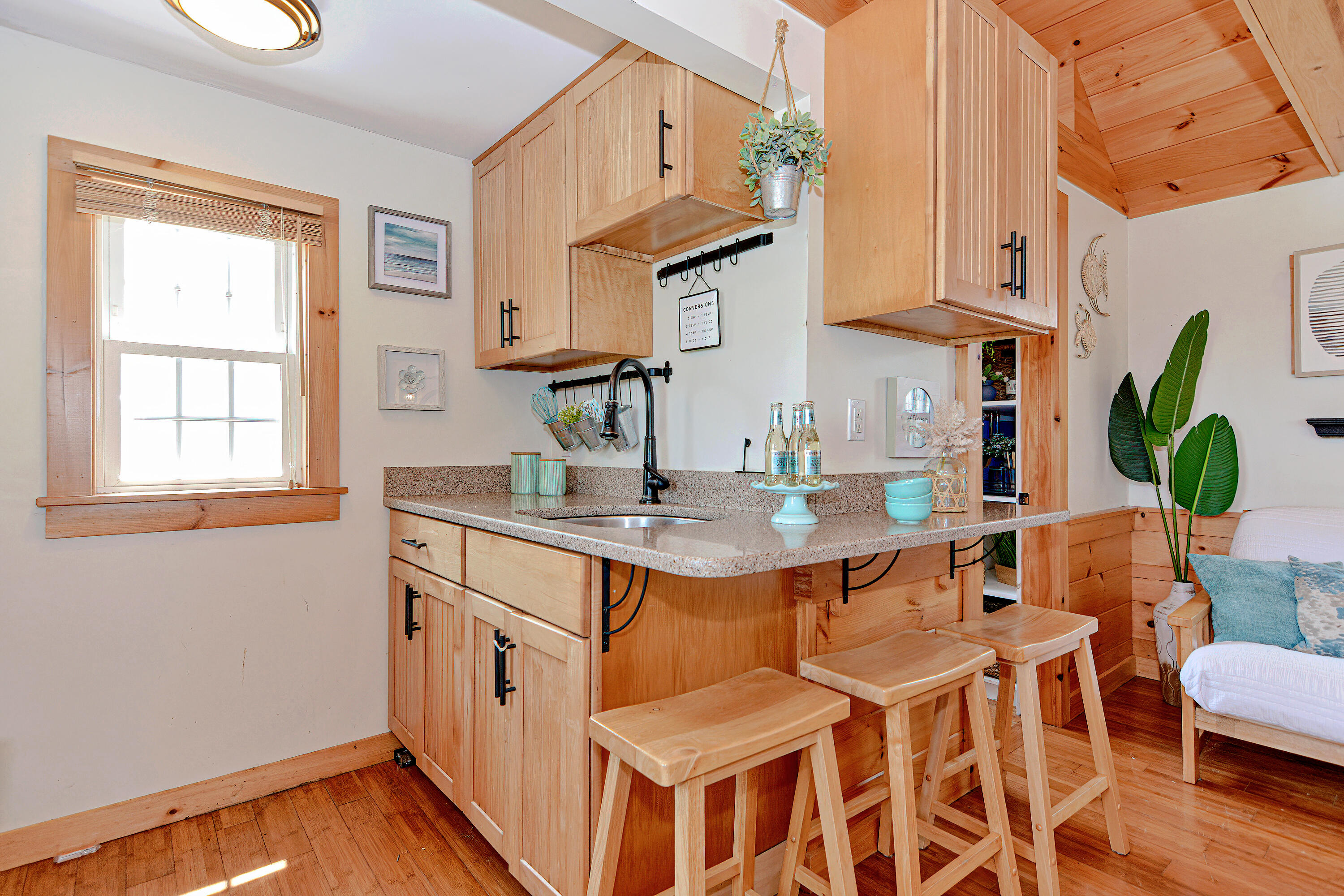 279 Harbor Point Road, Unit 12 Cummaquid, MA 02675 - Photo 8 of 35 a kitchen with stainless steel appliances granite countertop a sink a stove a dining table and chairs with wooden floor