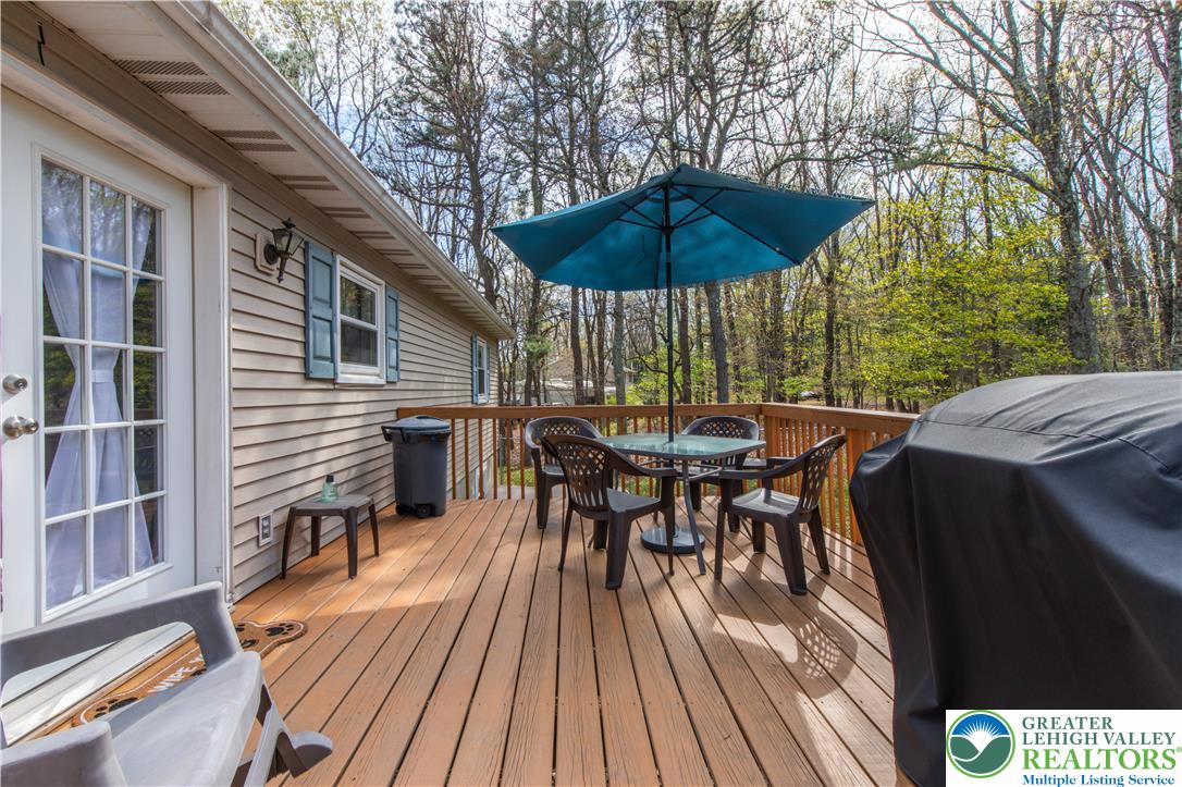 107 Shenkel Road Effort, PA 18330 - Photo 6 of 44 a view of a roof deck with table and chairs under an umbrella with wooden floor