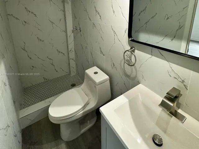 a white toilet sitting next to a bathroom sink