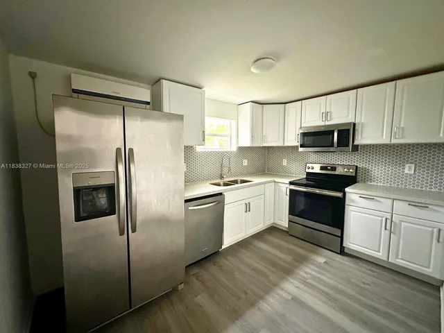 a kitchen with granite countertop a refrigerator stove and microwave