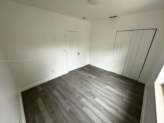 a view of a room with wooden floor
