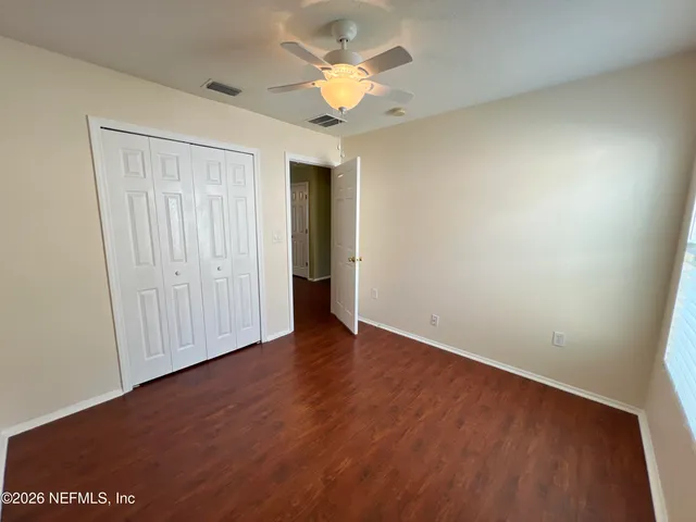 an empty room with wooden floor and closet