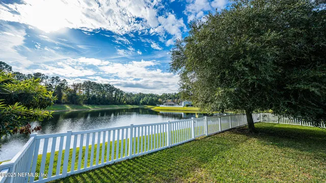 a kitchen with stainless steel appliances granite countertop a stove a sink a oven a dining table and chairs with wooden floor