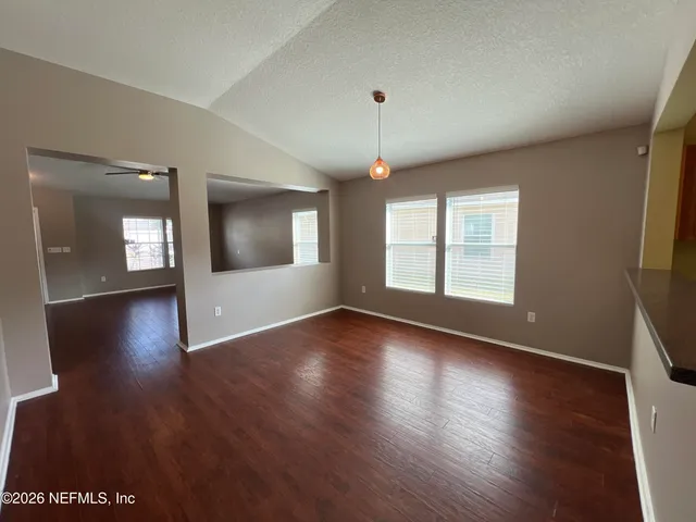 a view of a kitchen with kitchen island a sink wooden floor and a large window