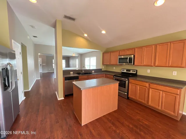 a kitchen with stainless steel appliances granite countertop a sink a stove and cabinets