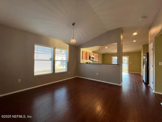 a view of an empty room with wooden floor