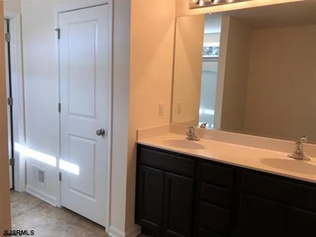 a bathroom with a double vanity sink and a mirror