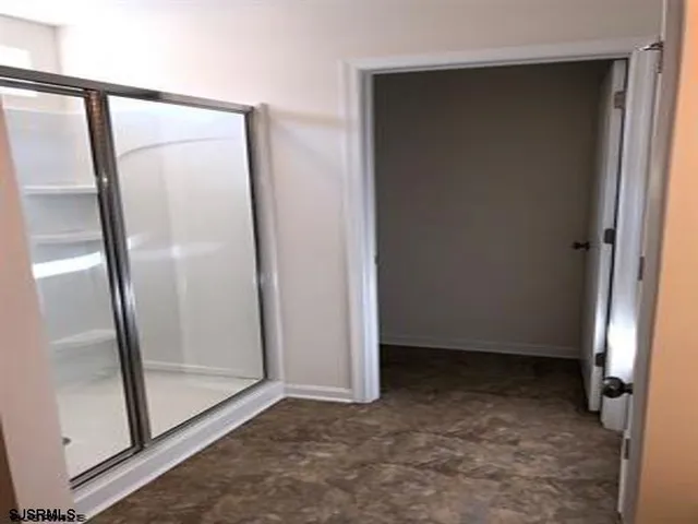 an empty room with mirror and door