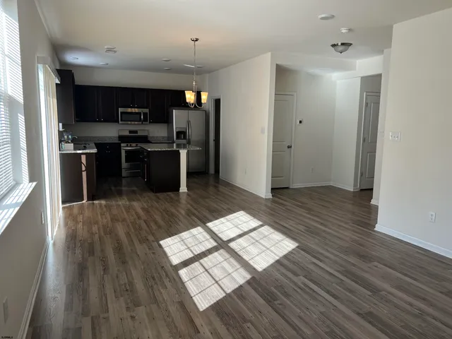 a kitchen with stainless steel appliances a refrigerator and wooden floor