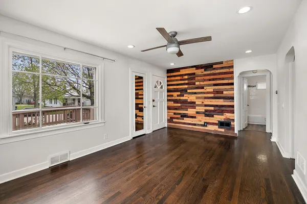 a view of an empty room with a window and wooden floor