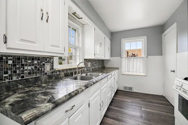 a kitchen with sink a stove and cabinets