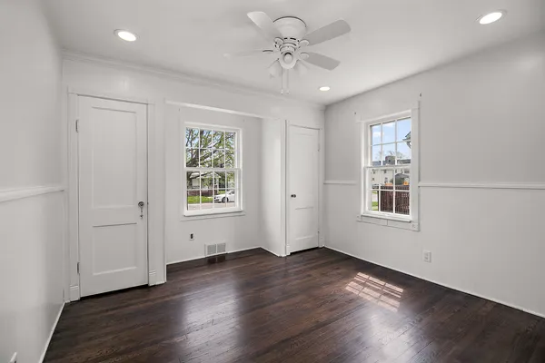 a view of an empty room with a window and wooden floor