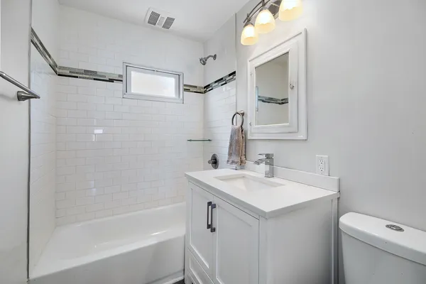 a bathroom with a sink toilet vanity and shower
