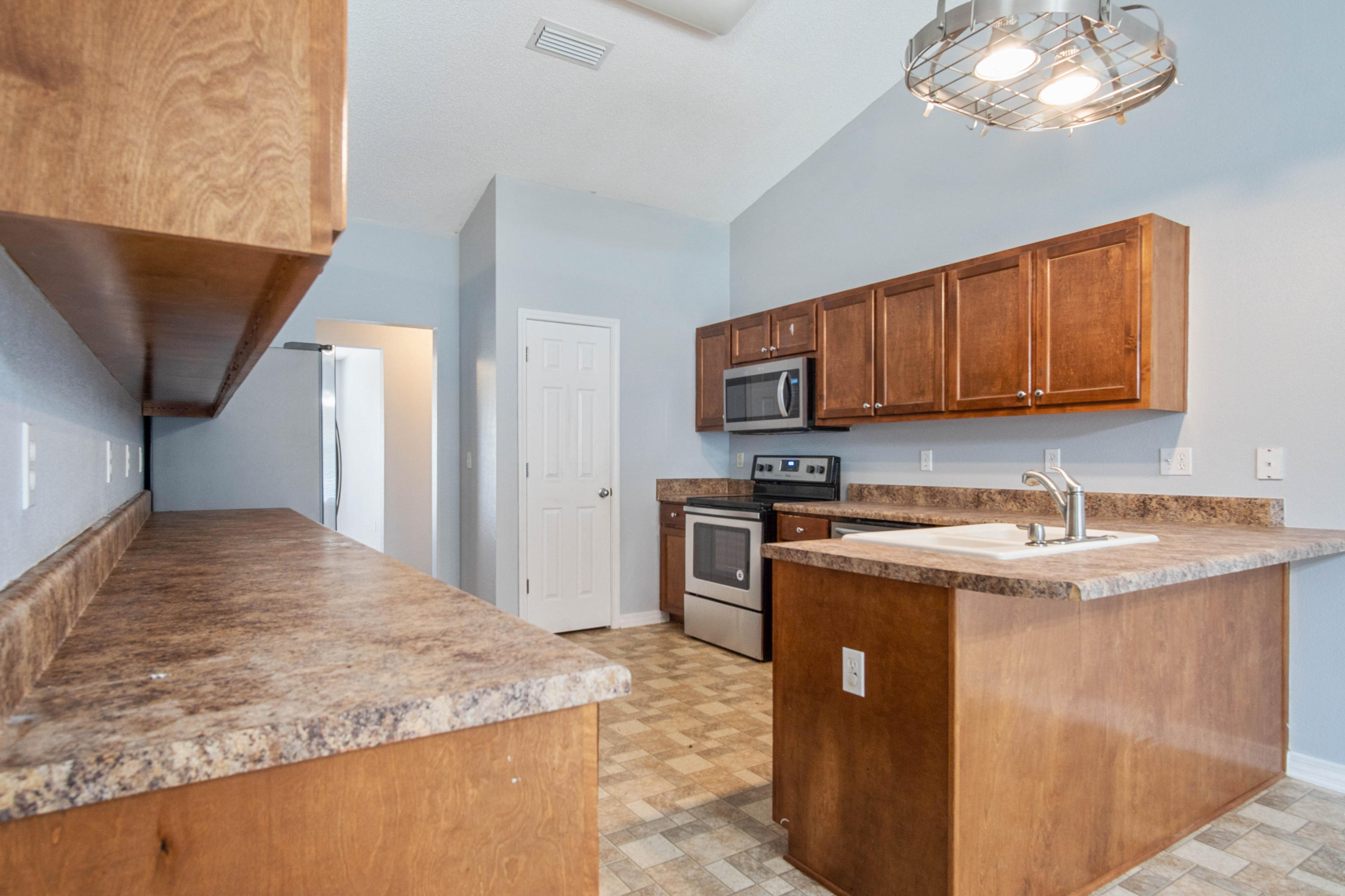 427 Triton Street Crestview, FL 32536 - Photo 15 of 32 a kitchen with stainless steel appliances granite countertop a sink stove and refrigerator