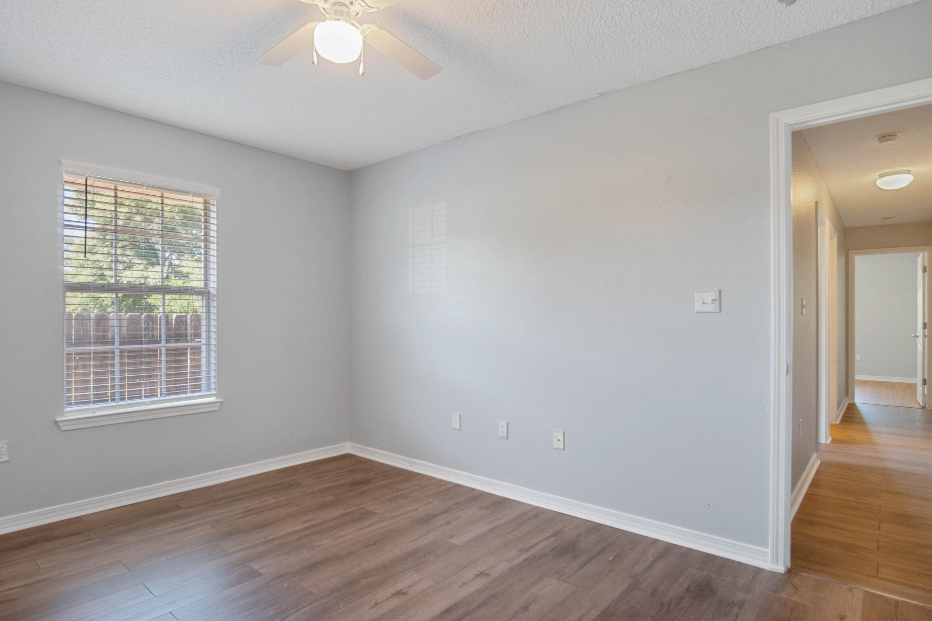 427 Triton Street Crestview, FL 32536 - Photo 19 of 32 an empty room with wooden floor and windows