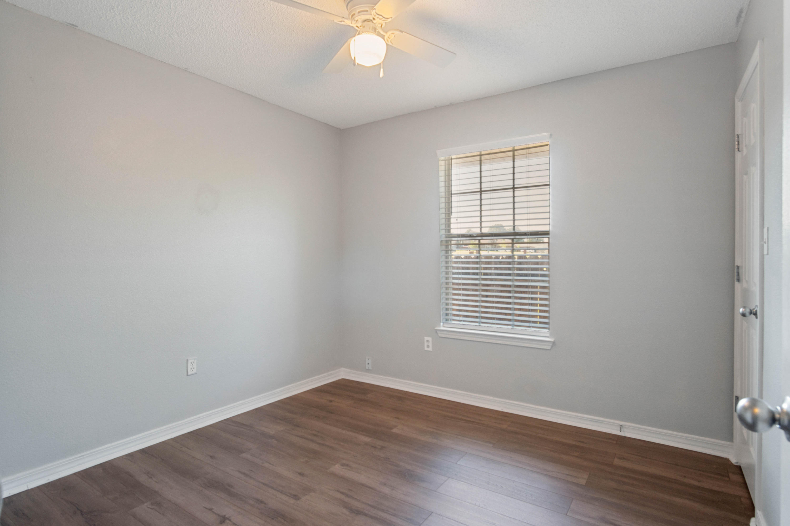 427 Triton Street Crestview, FL 32536 - Photo 20 of 32 an empty room with wooden floor and windows