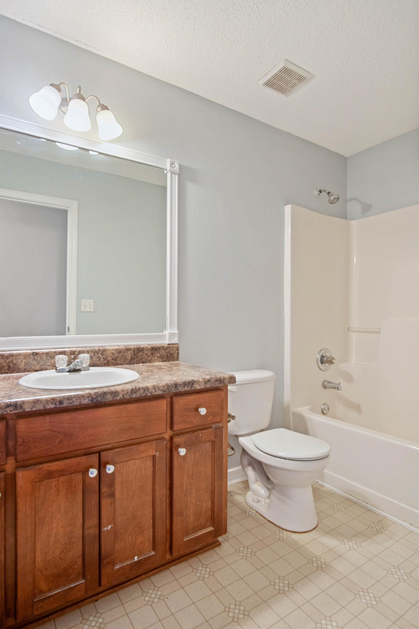 427 Triton Street Crestview, FL 32536 - Photo 22 of 32 a bathroom with a granite countertop toilet a sink and a mirror