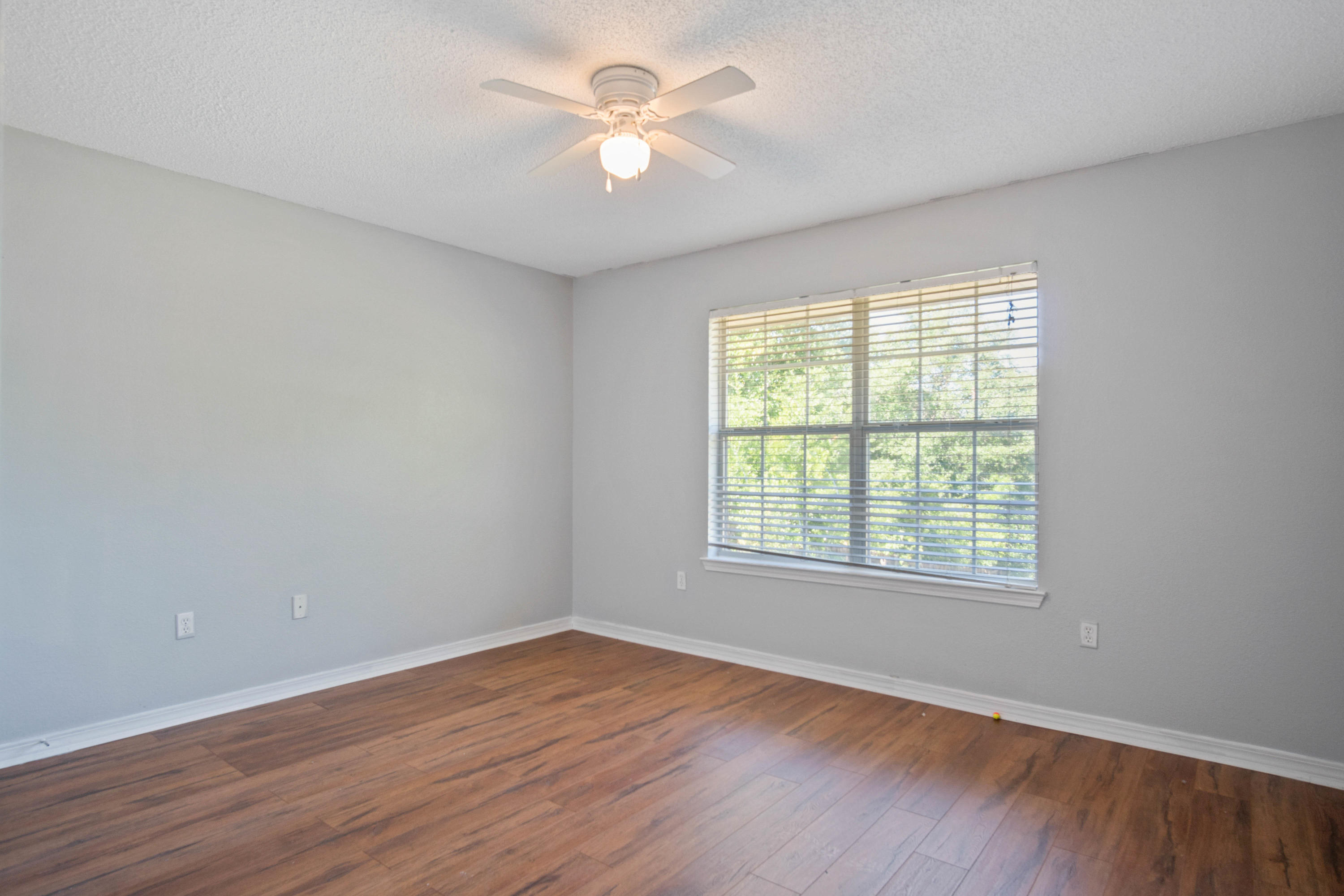 427 Triton Street Crestview, FL 32536 - Photo 23 of 32 an empty room with wooden floor and windows