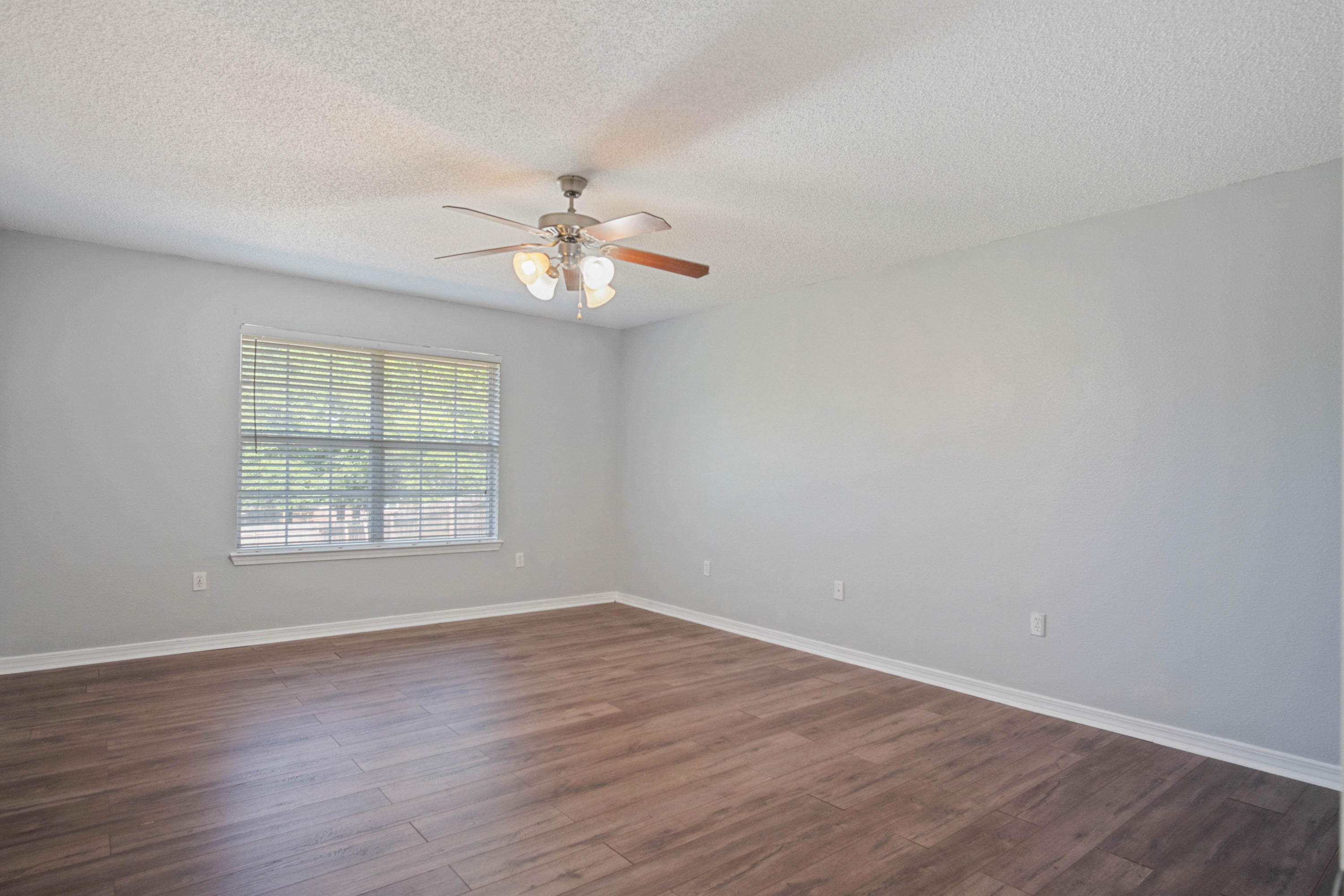 427 Triton Street Crestview, FL 32536 - Photo 25 of 32 an empty room with wooden floor and window