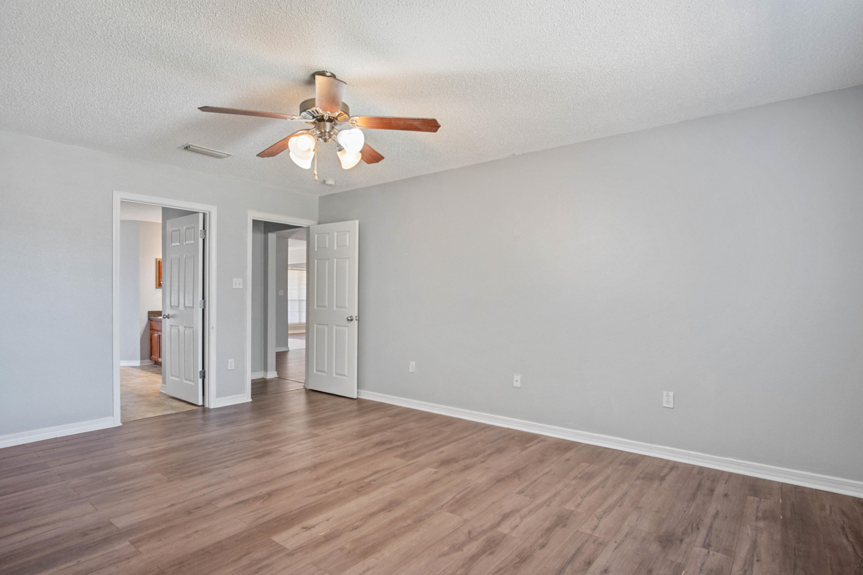 427 Triton Street Crestview, FL 32536 - Photo 27 of 32 a view of an empty room with wooden floor and a ceiling fan