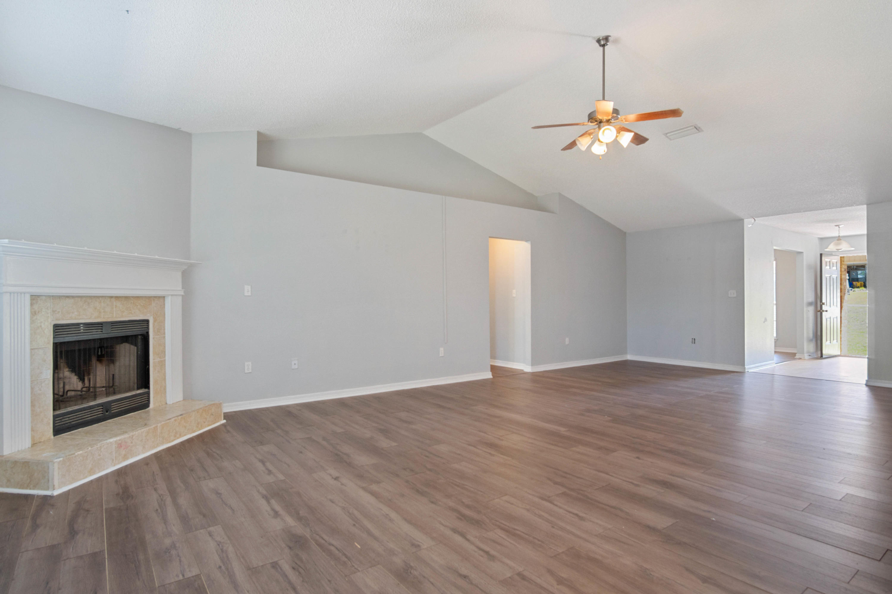 427 Triton Street Crestview, FL 32536 - Photo 9 of 32 a view of an empty room with wooden floor and fireplace
