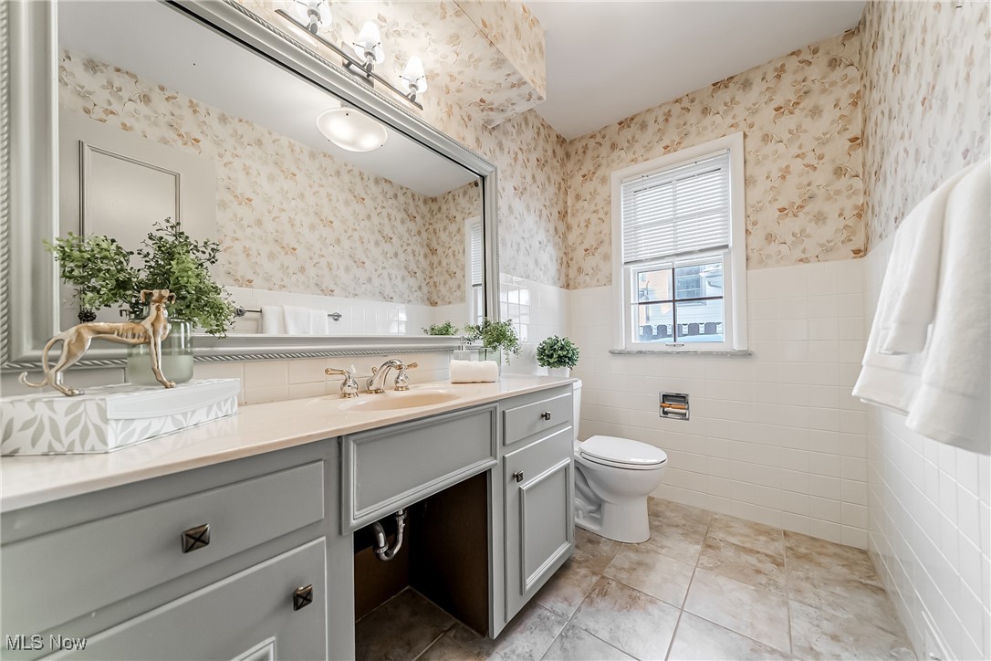18201 Shelburne Road Cleveland, OH 44118 - Photo 13 of 36 Half-bathroom with tile walls, toilet, vanity, and tile floors