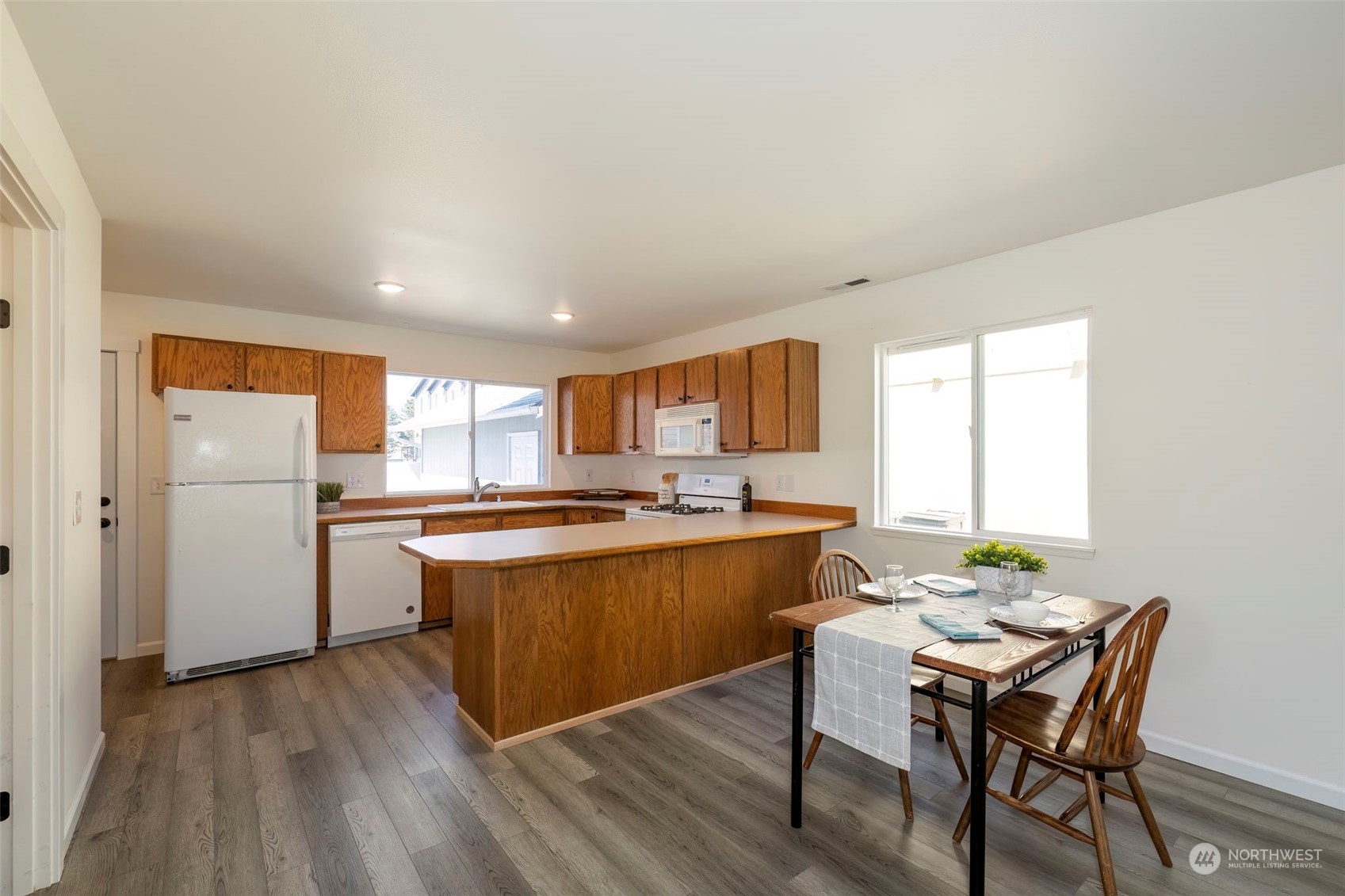 3982 Broadmoor Loop Bremerton, WA 98310 - Photo 13 of 40 a kitchen with stainless steel appliances granite countertop a stove a sink dishwasher and a refrigerator with wooden floor