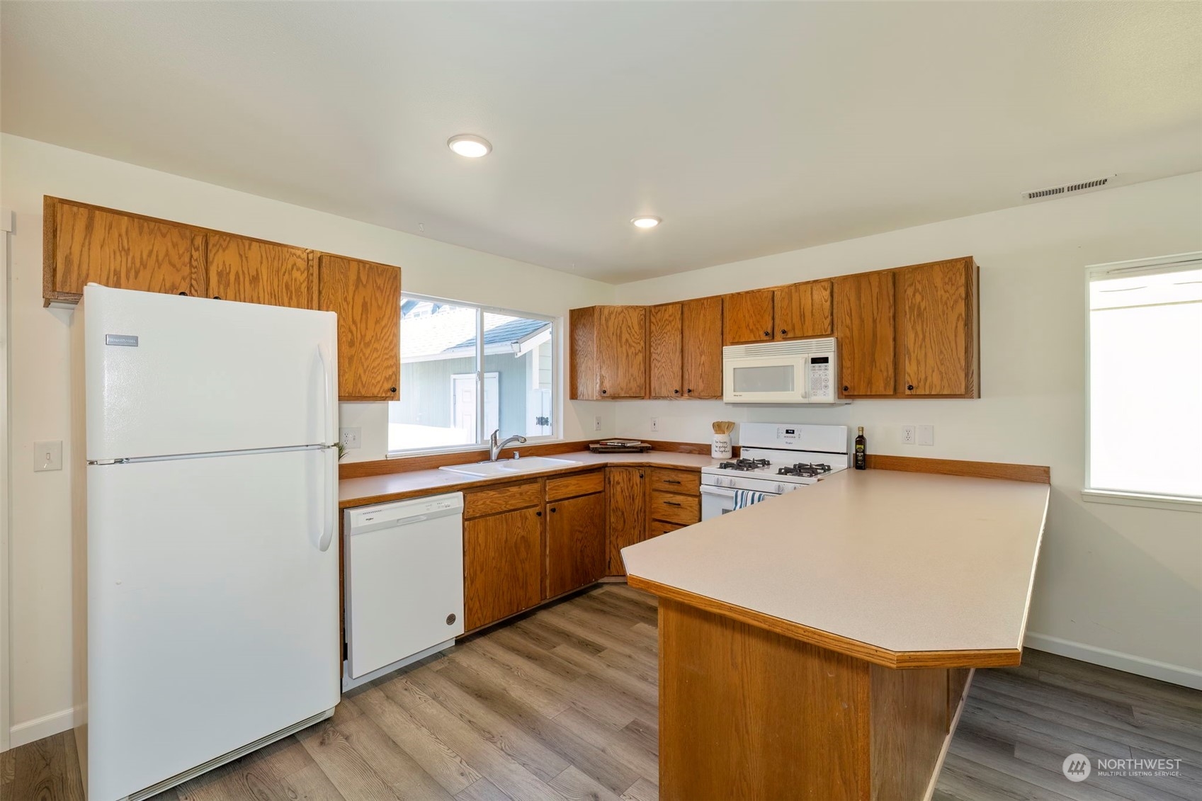 3982 Broadmoor Loop Bremerton, WA 98310 - Photo 15 of 40 a kitchen with a refrigerator a stove a sink dishwasher and wooden floor