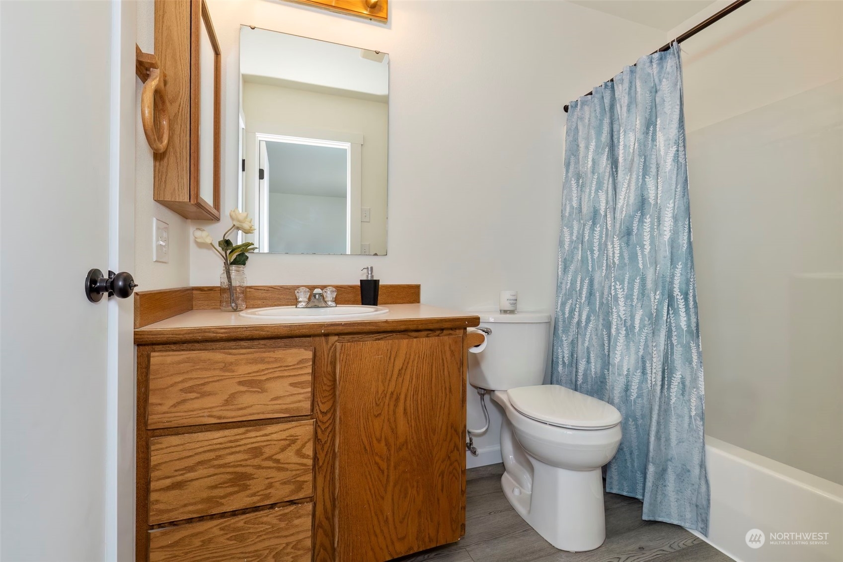 3982 Broadmoor Loop Bremerton, WA 98310 - Photo 27 of 40 a bathroom with a sink a toilet a mirror and shower curtain