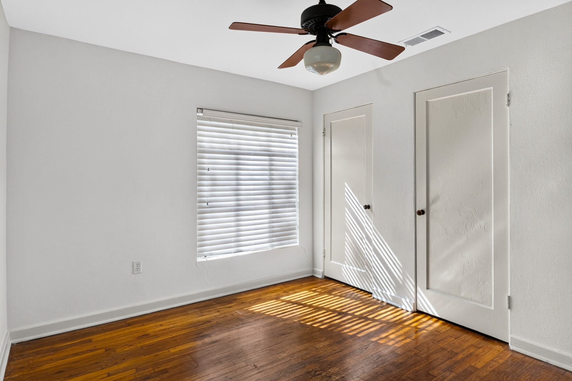 1302 Kirkwood Road, Unit B Austin, TX 78722 - Photo 16 of 21 Hardwood floors and a ceiling fan create a comfortable atmosphere in this inviting space.