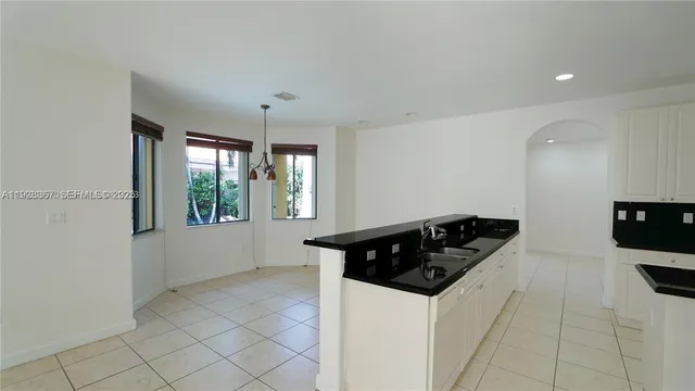 a kitchen with stainless steel appliances a refrigerator a stove a sink and white cabinets